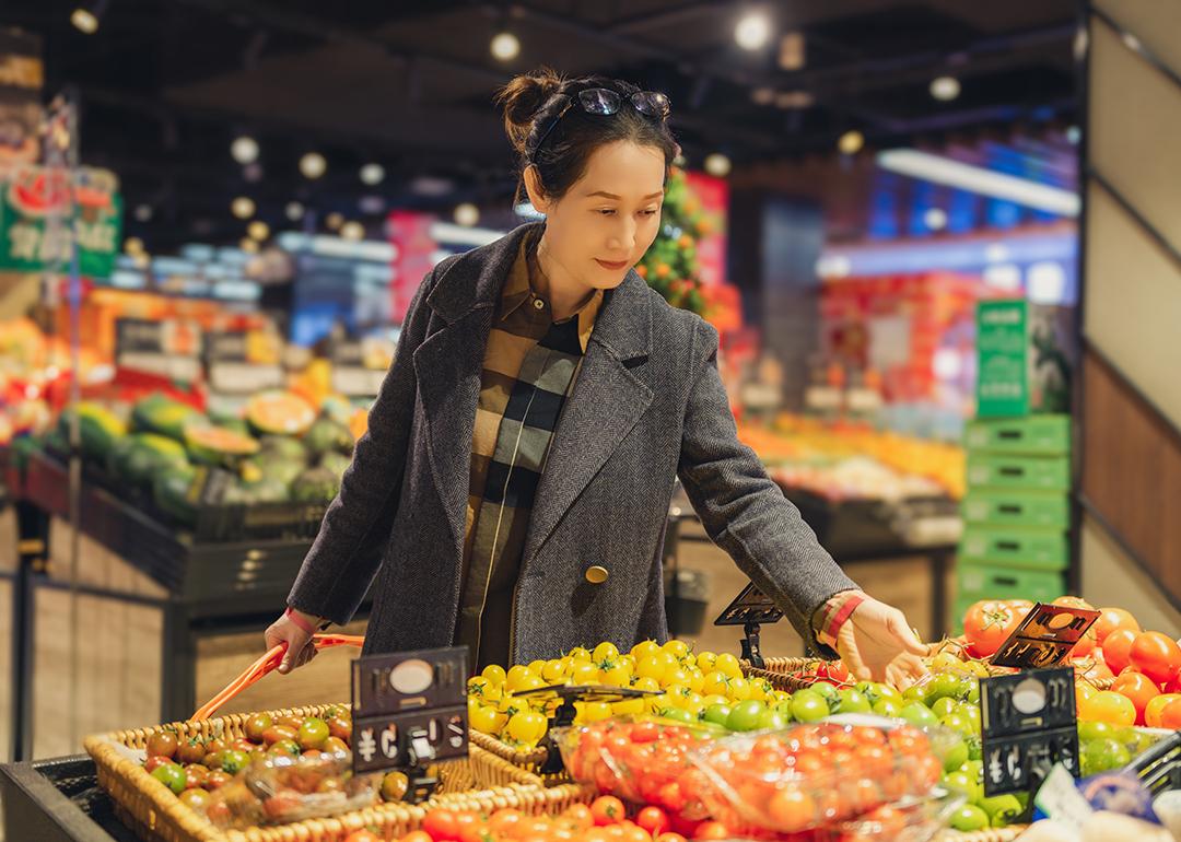 Young woman selecting fresh produce at the grocery store.