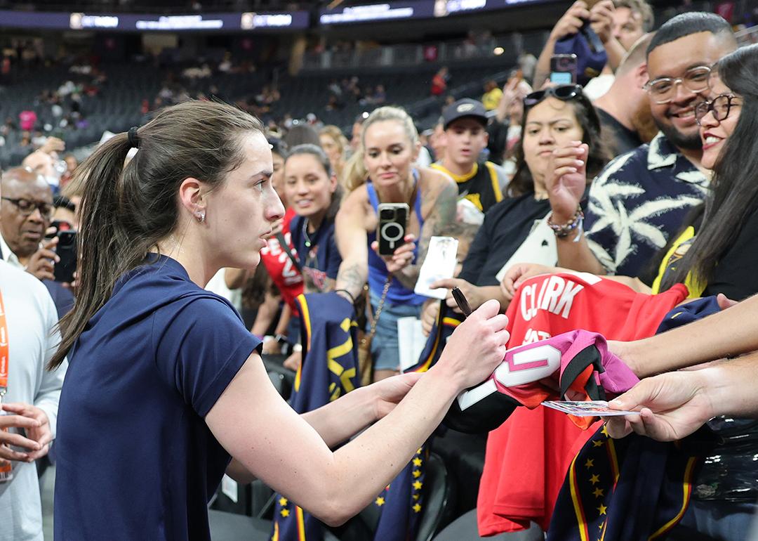 Caitlin Clark #22 of the Indiana Fever signs autographs for fans after warming up before a game against the Las Vegas Aces at T-Mobile Arena on June 22, 2025 in Las Vegas, Nevada.