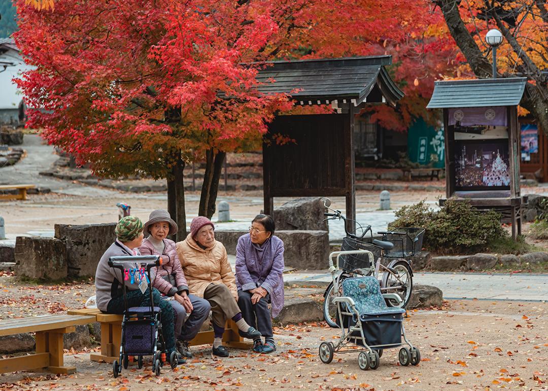 Four elderly women chatting in a garden in Takayama, Japan.