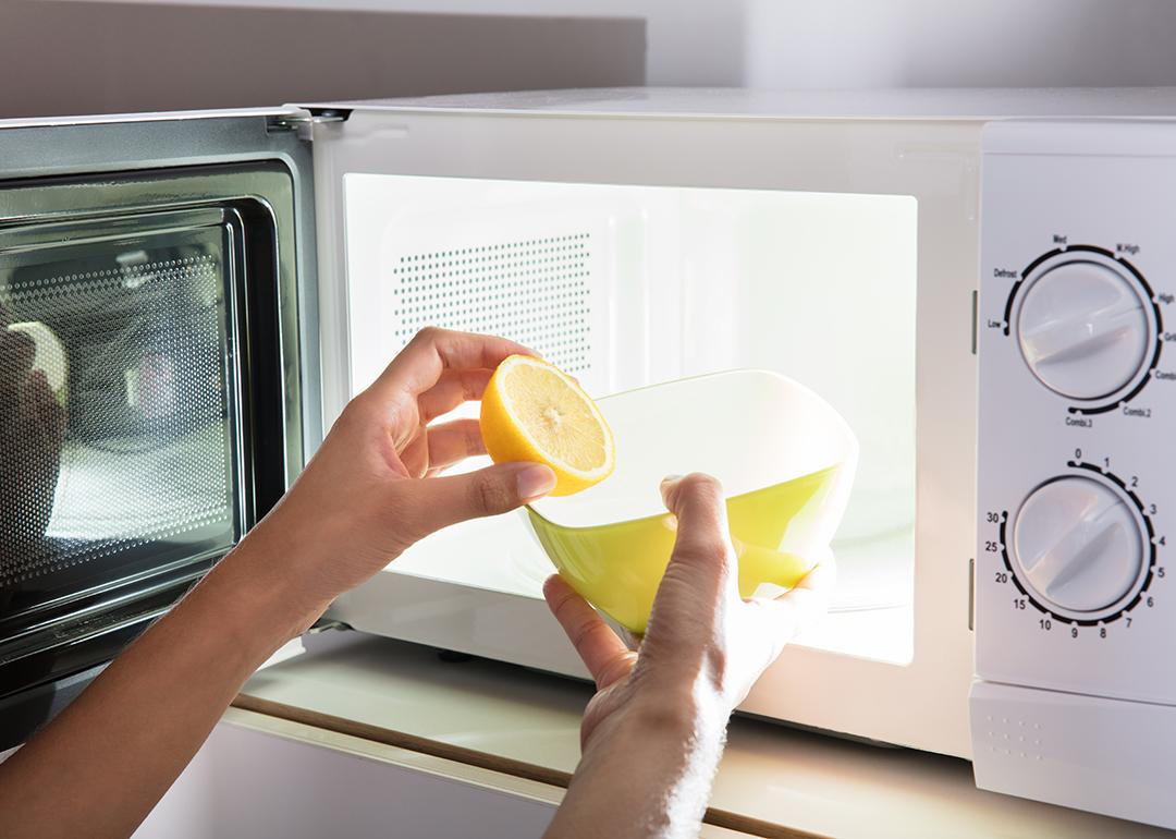 Microwave being cleaned with water and lemon.