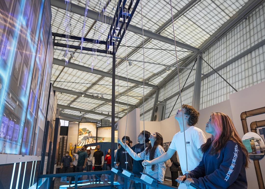 People interacting with a CityWorks exhibit exploring the water and wastewater infrastructure system.
