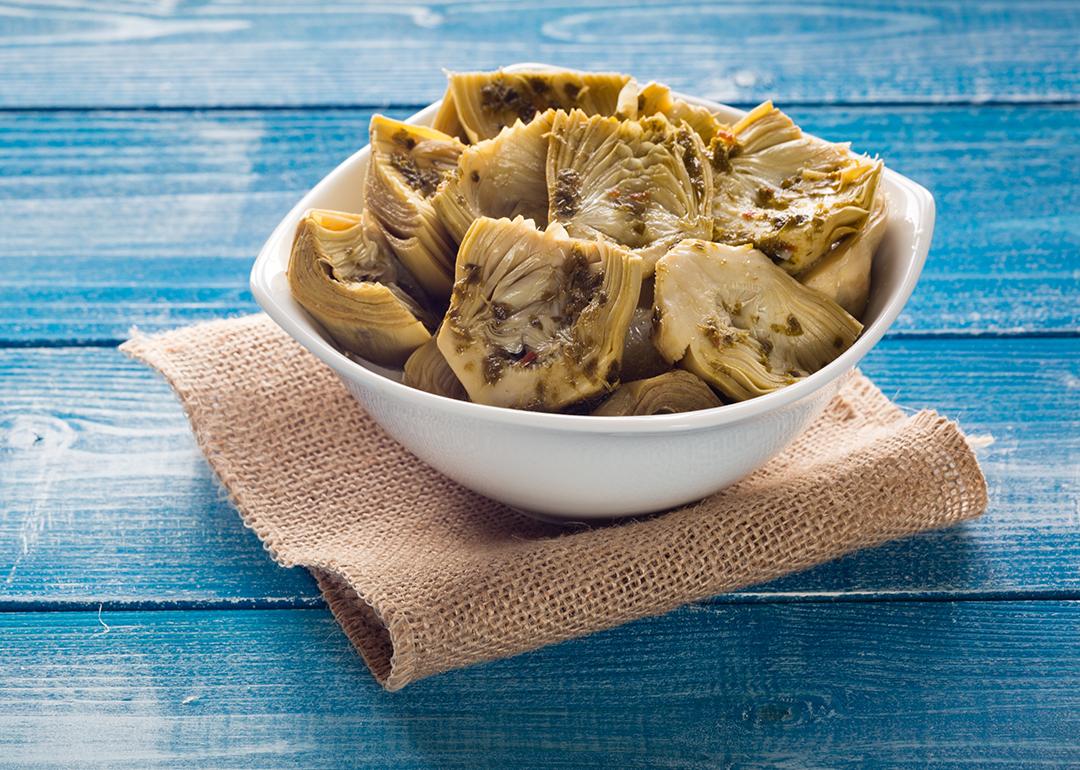 A bowl of grilled artichokes in oil.