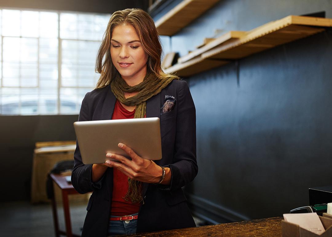 E-commerce businesswoman looking at her tablet in her workshop.