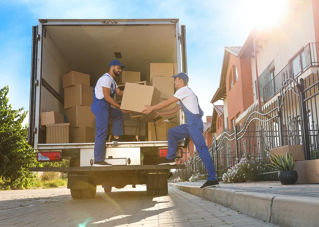 Two workers unloading boxes from a truck servicing a relocation.