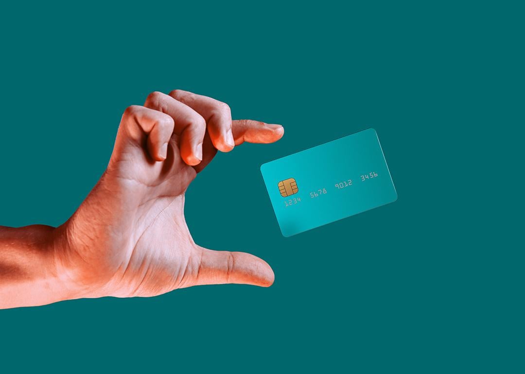 Hand reaching for a credit card mid-air.