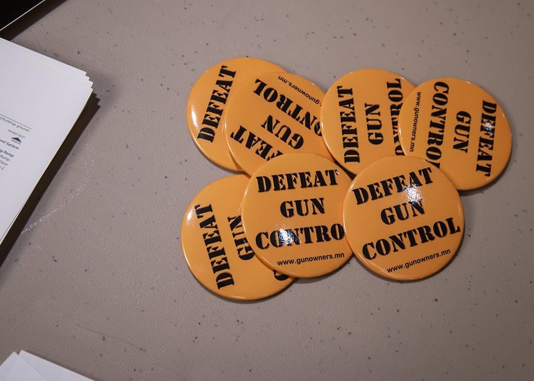 Orange "Defeat gun control" buttons set out on a table for people after they sign their name to give to legislators working on gun control bills.