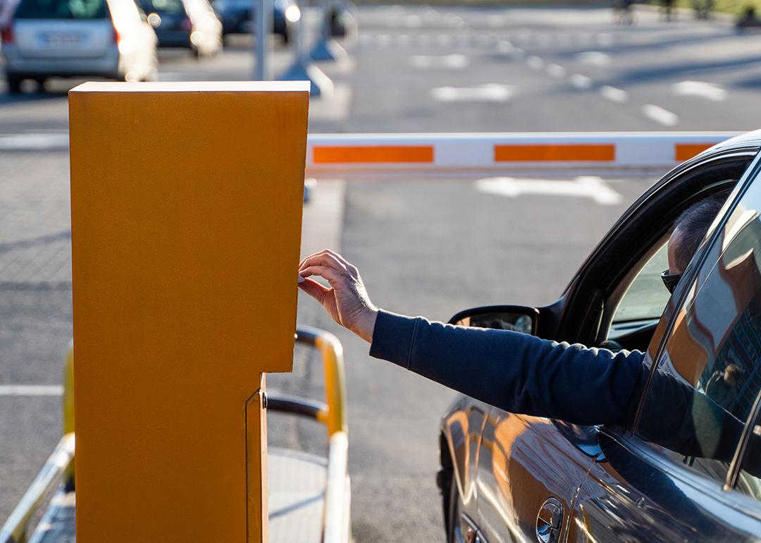 Person in the car paying for a parking ticket.