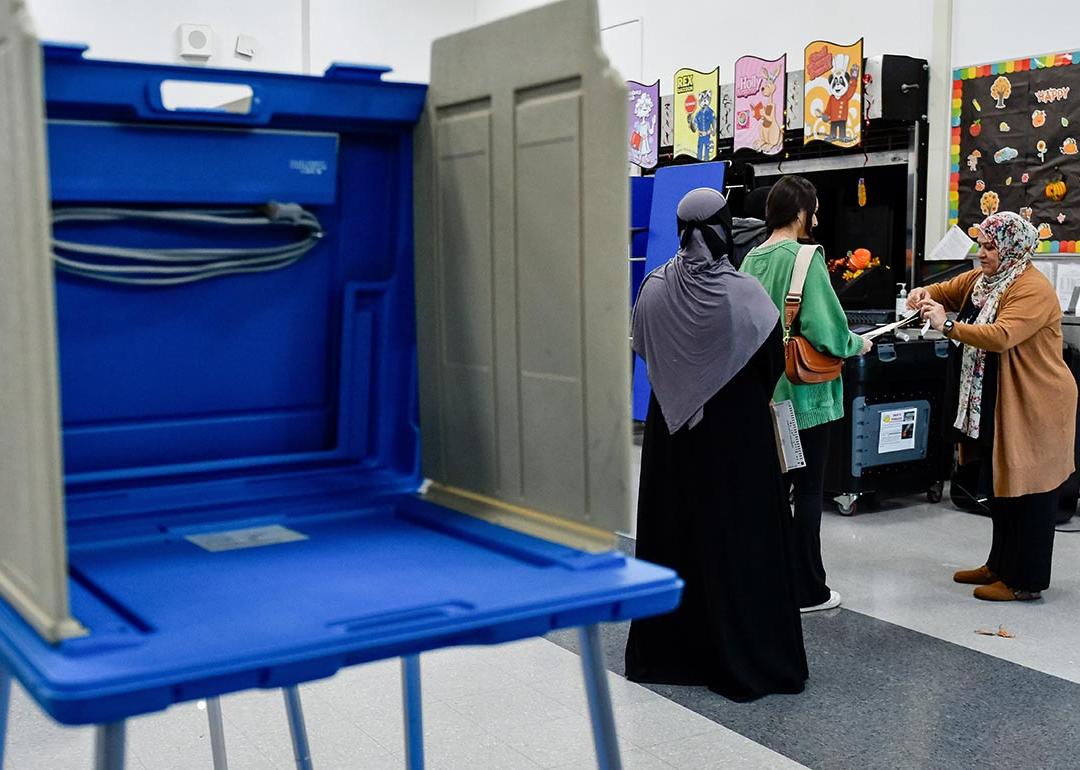 An election official assists voters ready to turn in their ballots for the US presidential and congressional elections at Dearborn High School in Dearborn, MI, United States on November 05, 2024.