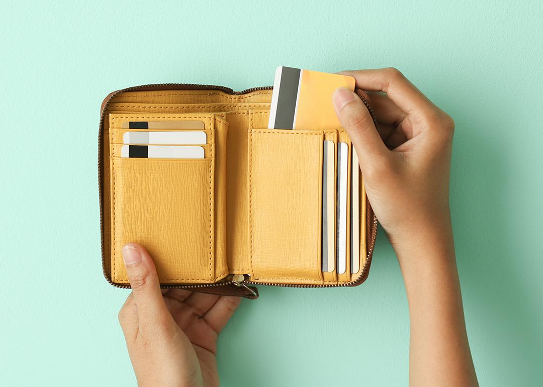 Person taking out a credit card from a wallet.