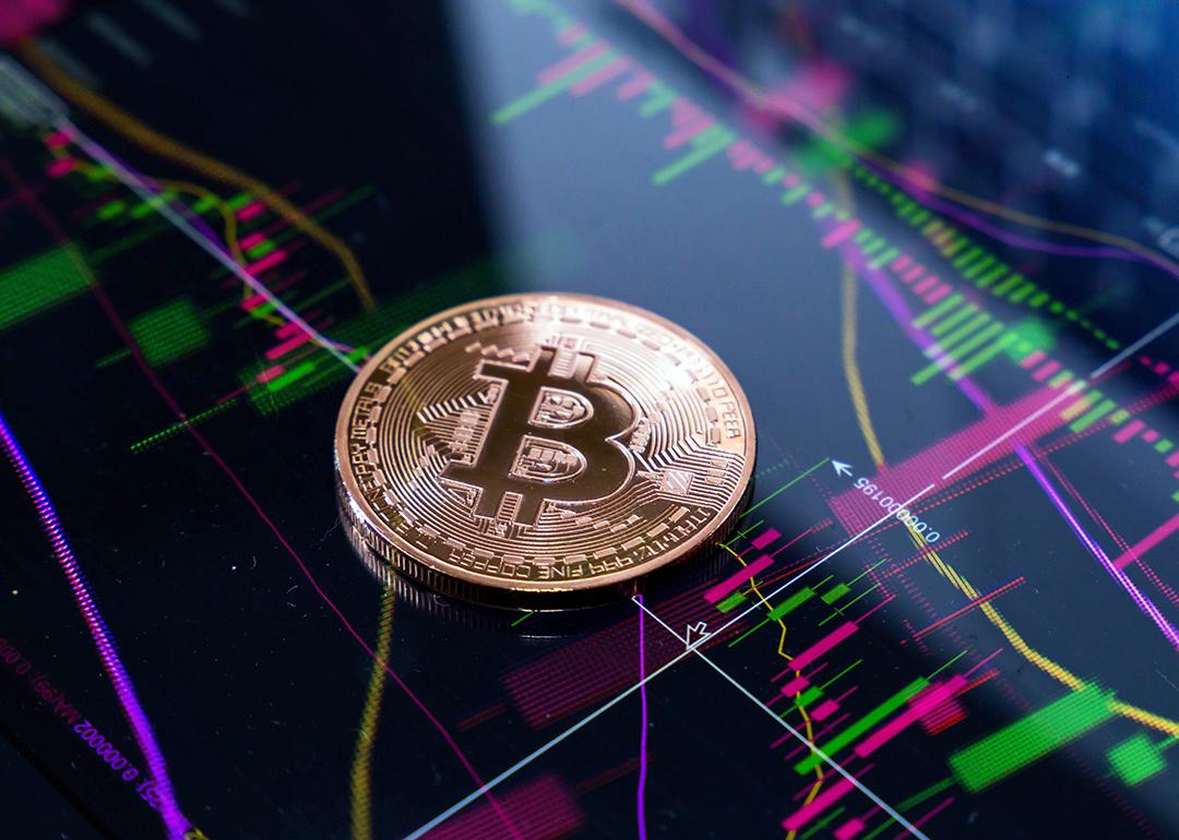 Gold bitcoin on top of finance graphic charts.