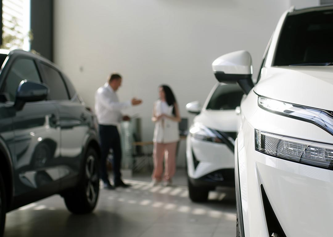 A manager and an interested buyer in a car dealership.
