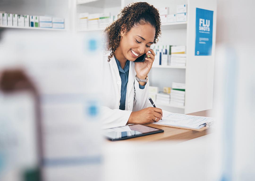A pharmacist taking a call and listing a customer's order.