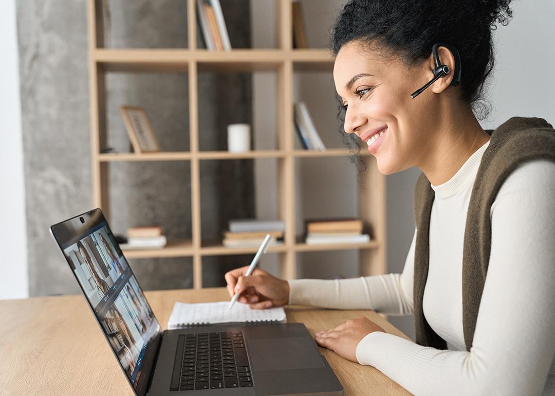 Young female professional engaged in a virtual meeting while working from home.
