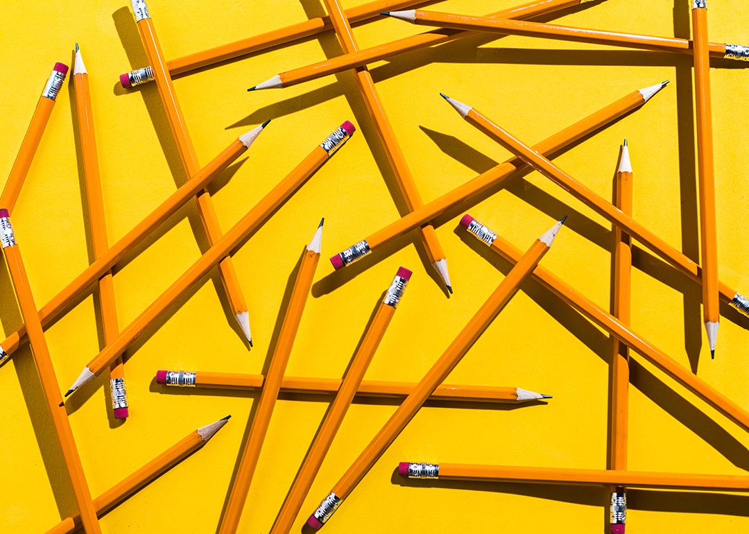 Scattered pencils on a yellow background.