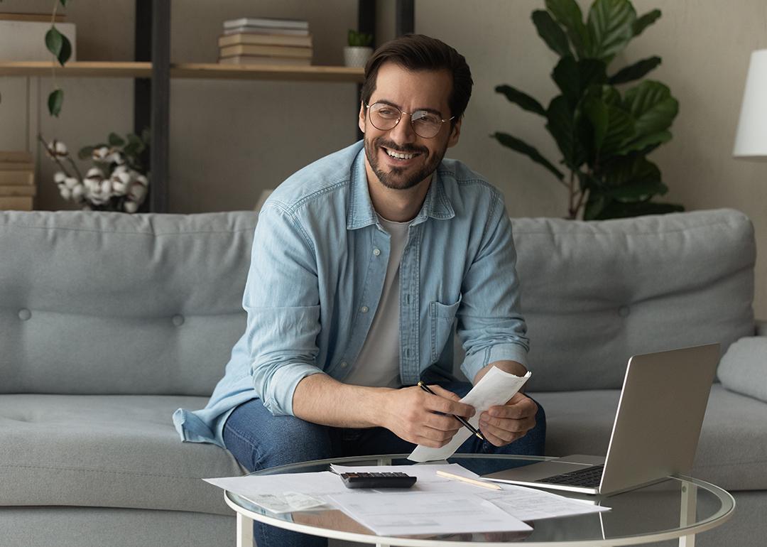 Happy man holding credit documents.