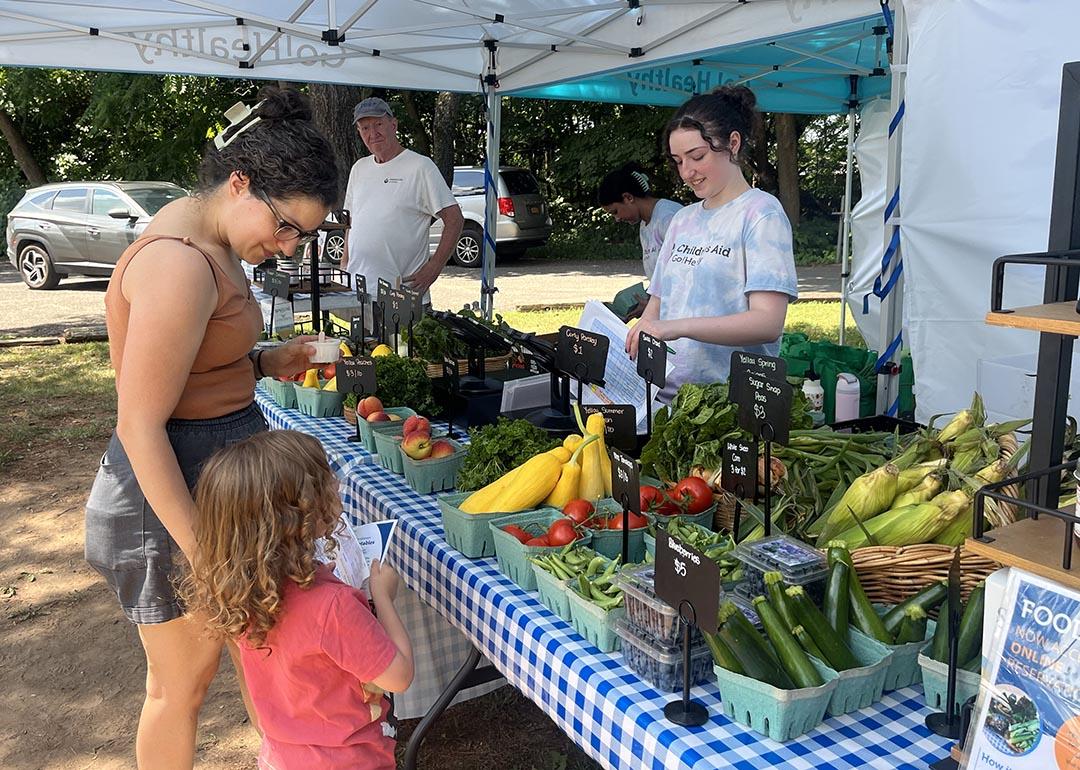 Ana Garcia, 41, and her 3-year-old son, Elliott, pick up a Food Box at a table full of colorful produce at the Goodhue Community Center on Staten Island 