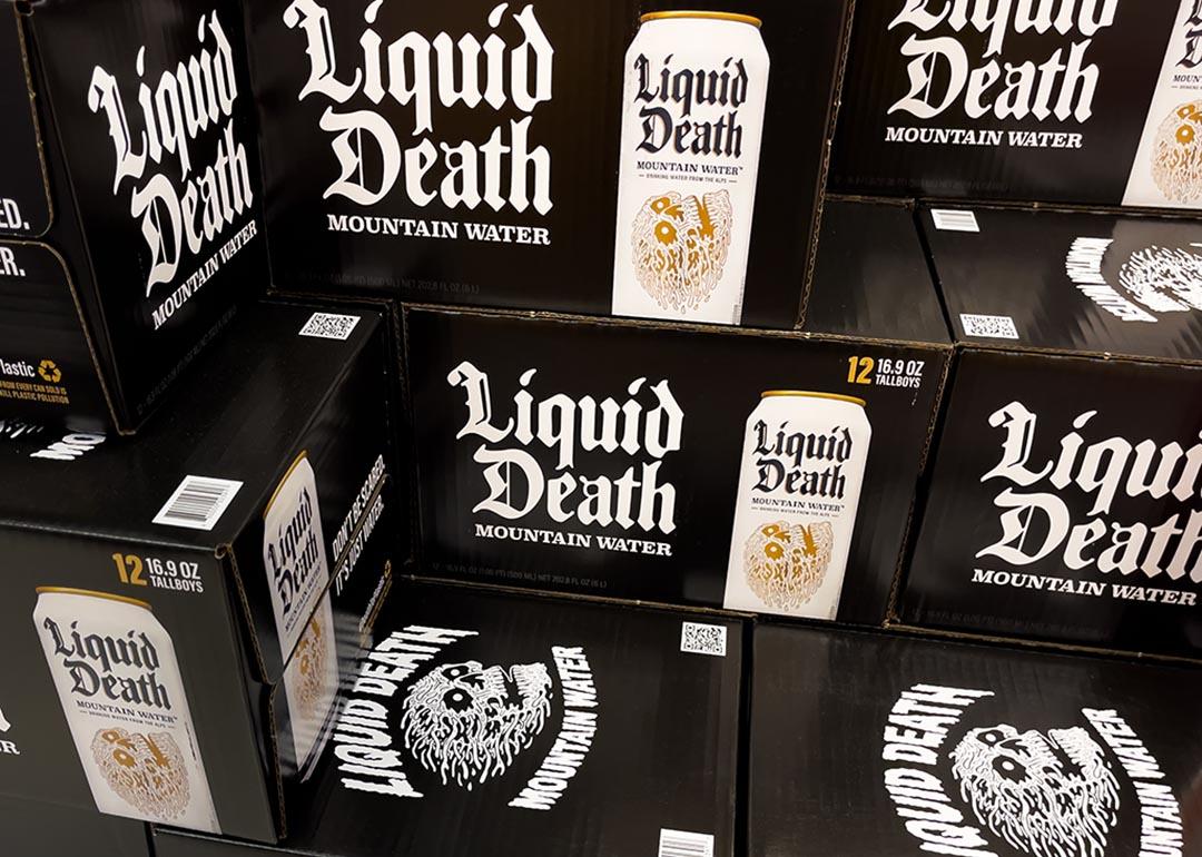 Black boxes of Liquid Death canned mountain water grocery store display.
