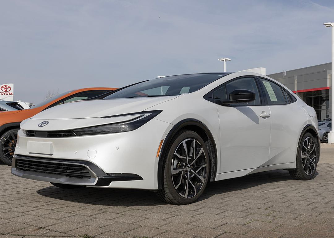 A used white Toyota Prius on display at a dealership.