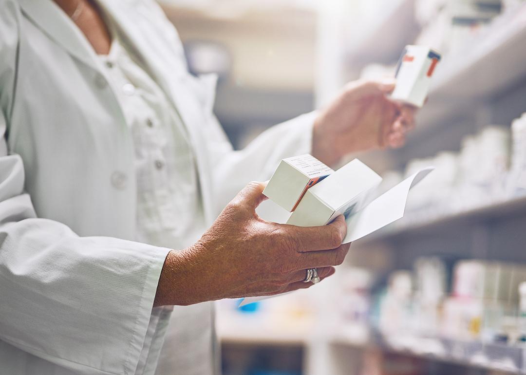 Pharmacist looking at multiple boxes of drugs.
