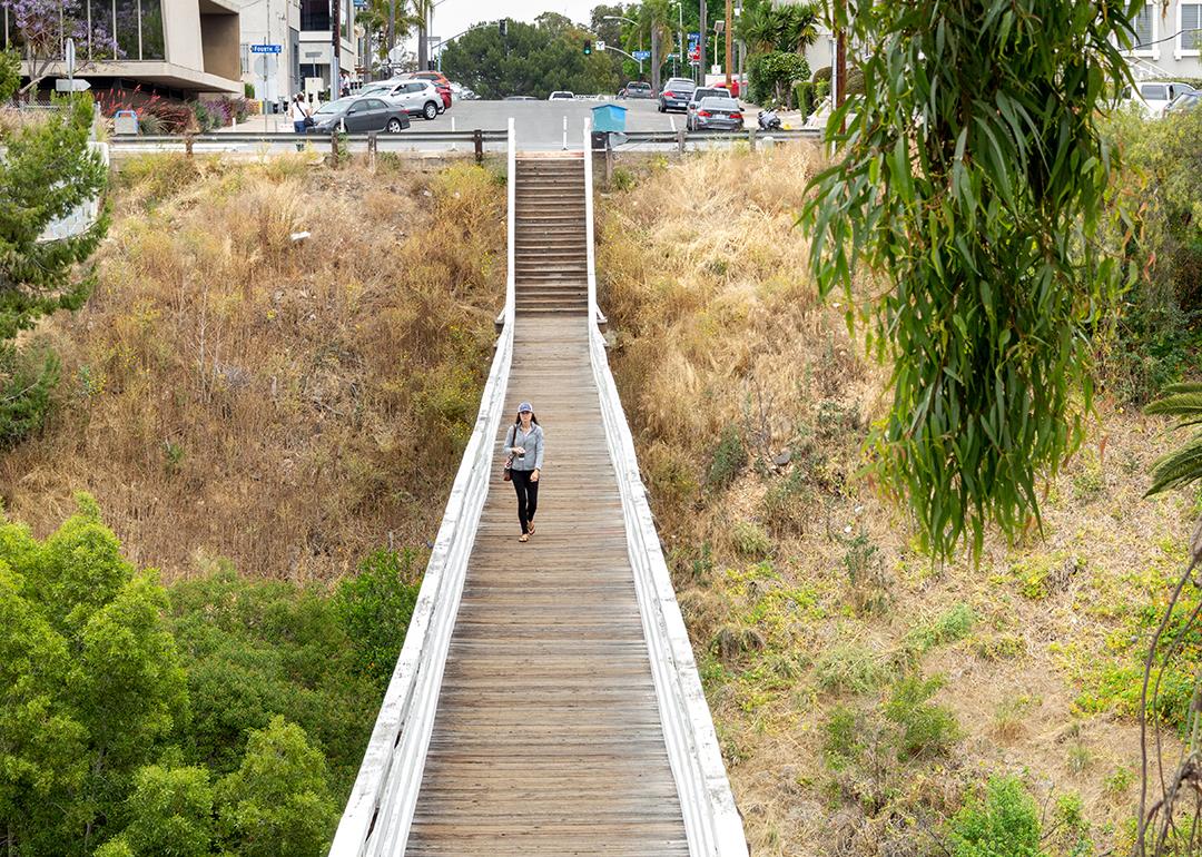 A woman walking across the Quince Street Bridge in Banker's Hills in San Diego, California.