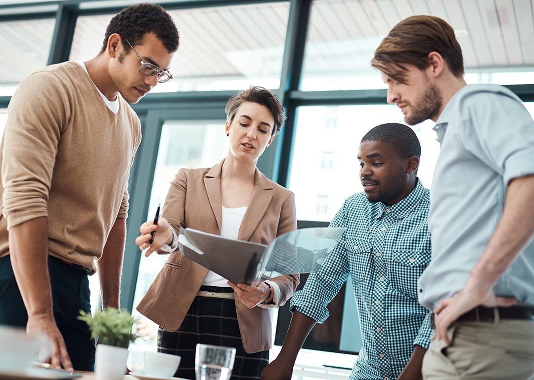 A creative team in an office analyzing expense management reports.