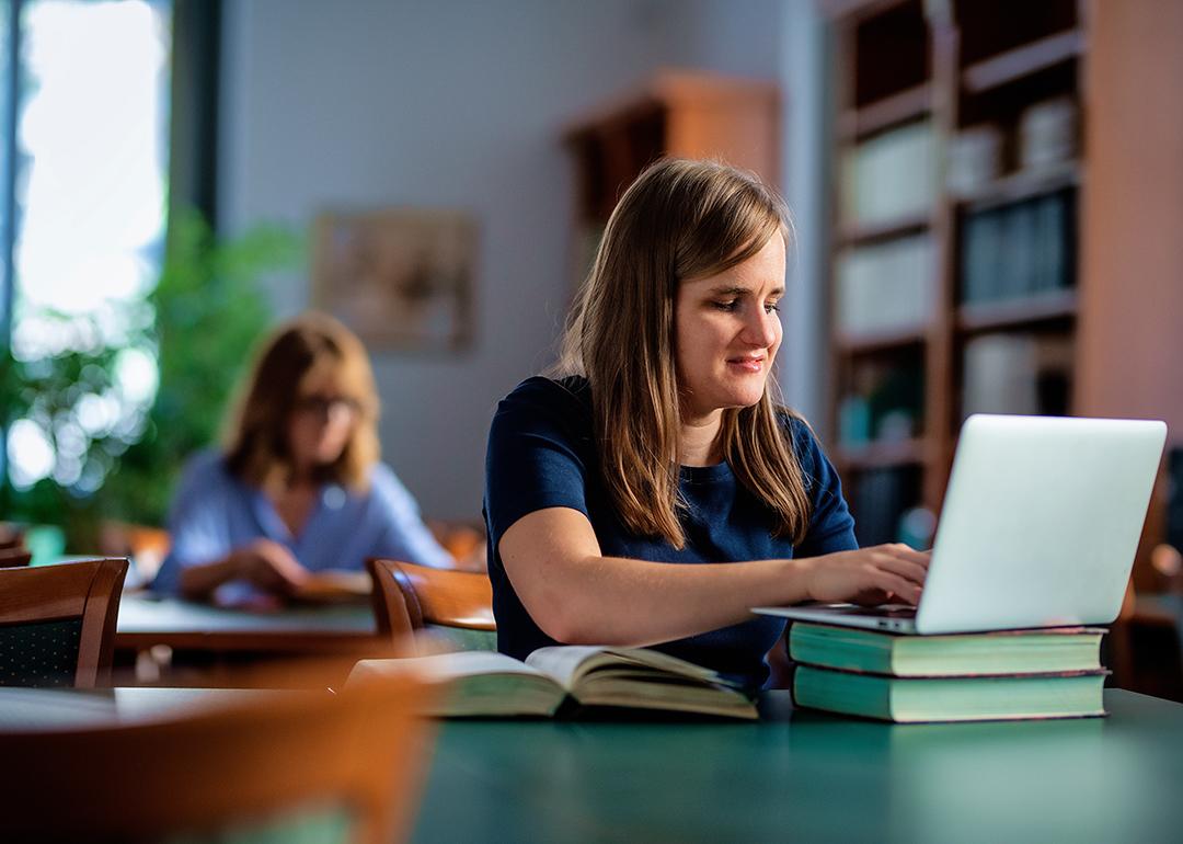 A visually impaired young woman studying in a university library.