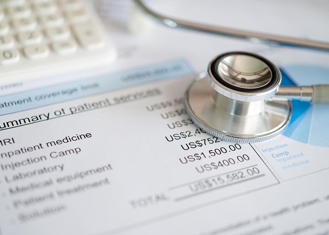 Stethoscope on top of medical expenses bill.