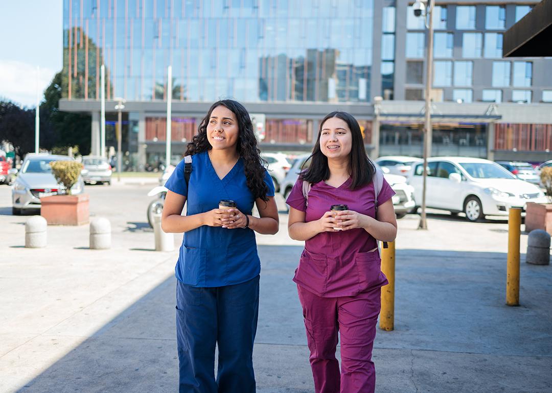 Two young female nurses having coffee after work.