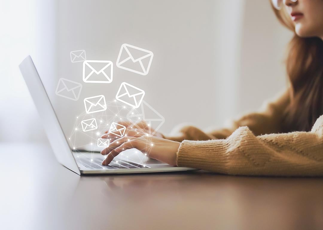 A marketing professional working on her laptop illustrated with graphics of email and newsletter.