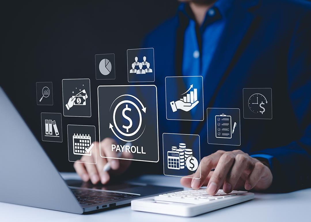 A payroll employee working on his laptop illustrated with payroll management system concept graphics.