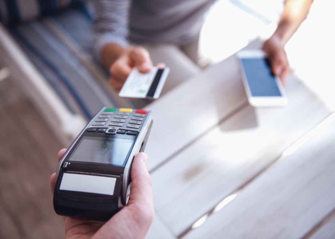 Person paying with a credit card at a cafe.