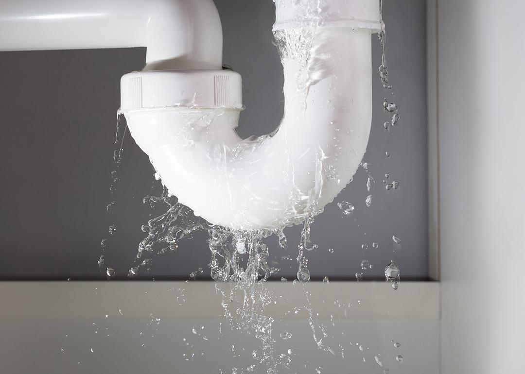 Close-up of a water pipe from under the sink leaking.