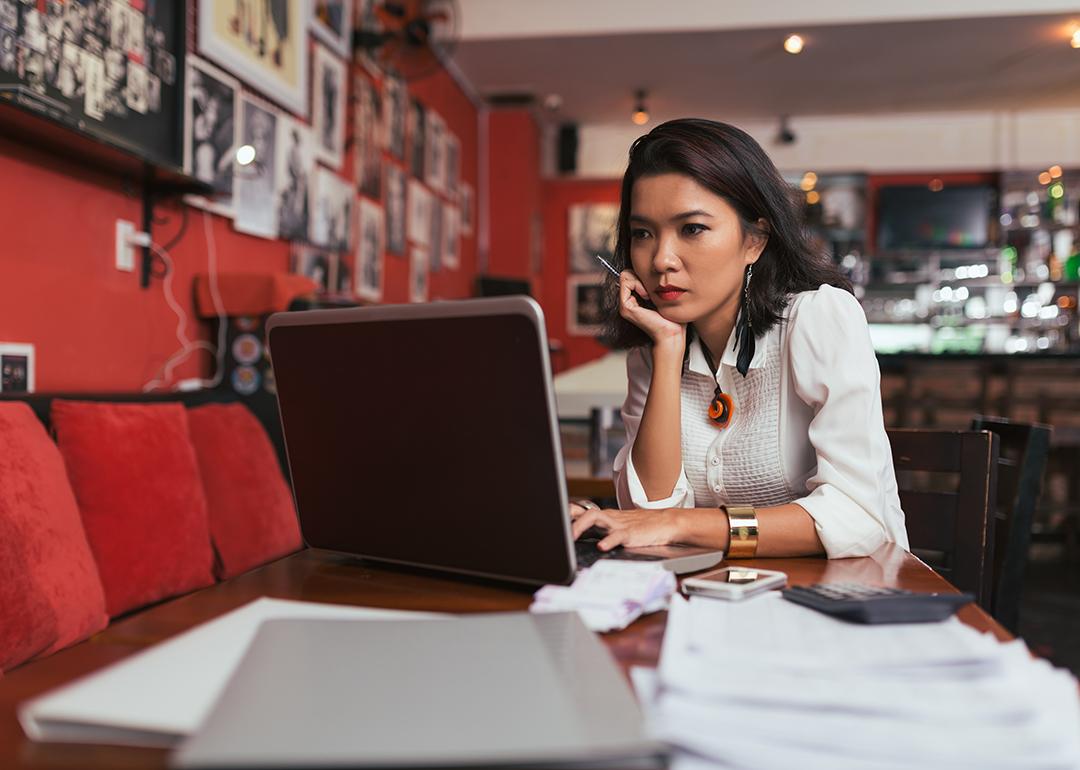 A female bar owner using her laptop to pay business expenses online.
