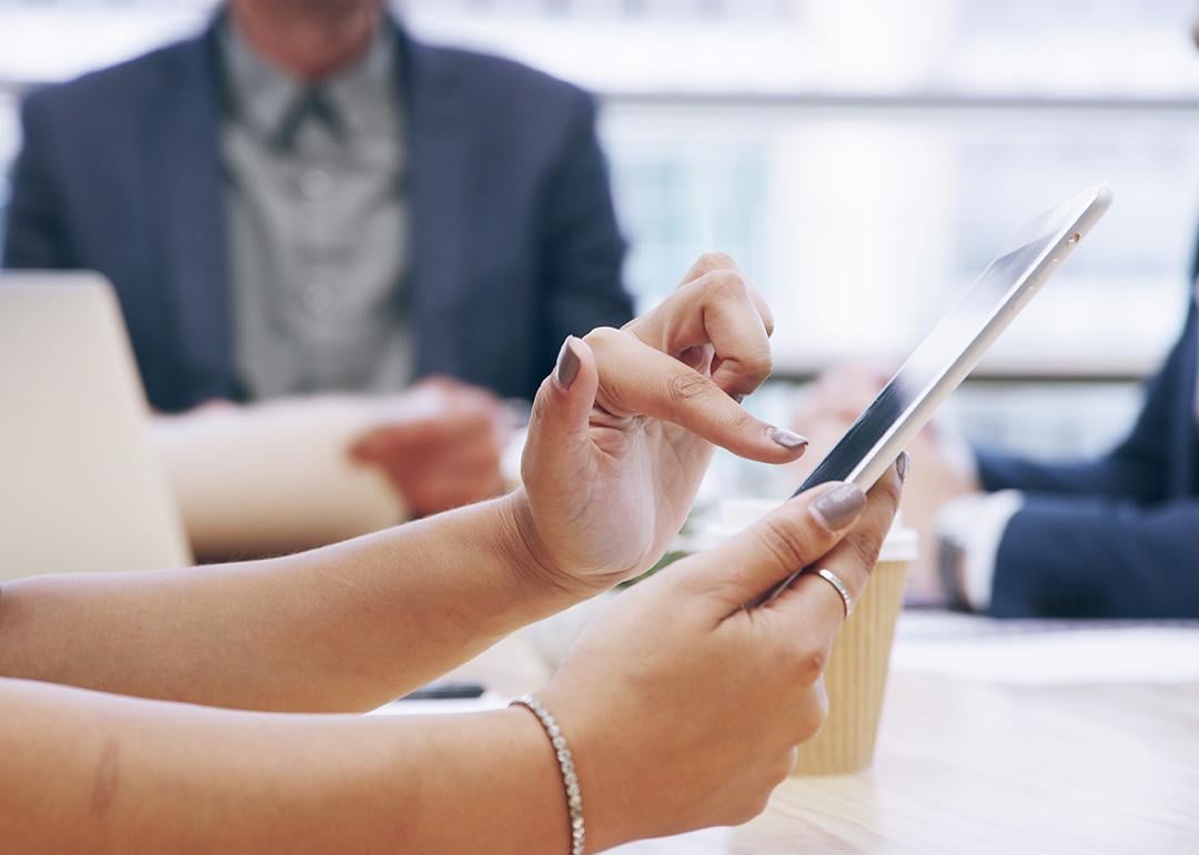 Businesswoman using a tablet during a team meeting.