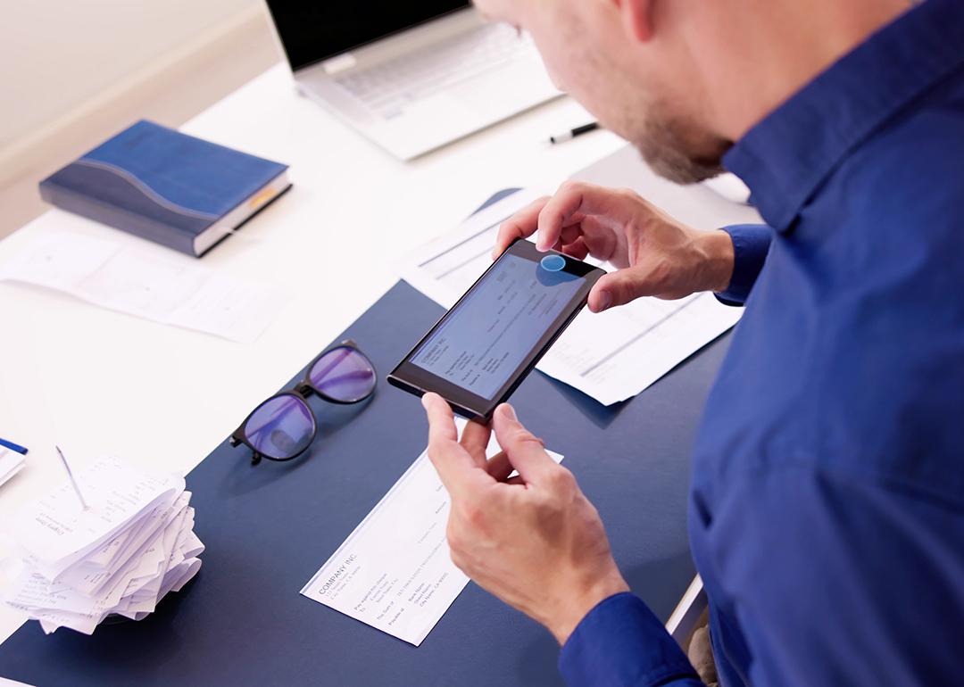 Business employee taking a photo of a deposit check.