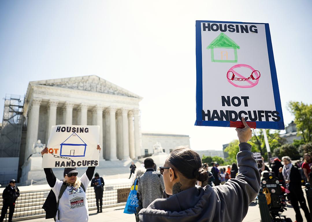Homeless rights activists hold up signs saying "Housing, Not Handcuffs" outside of the U.S. Supreme Court on April 22, 2024 in Washington, DC.