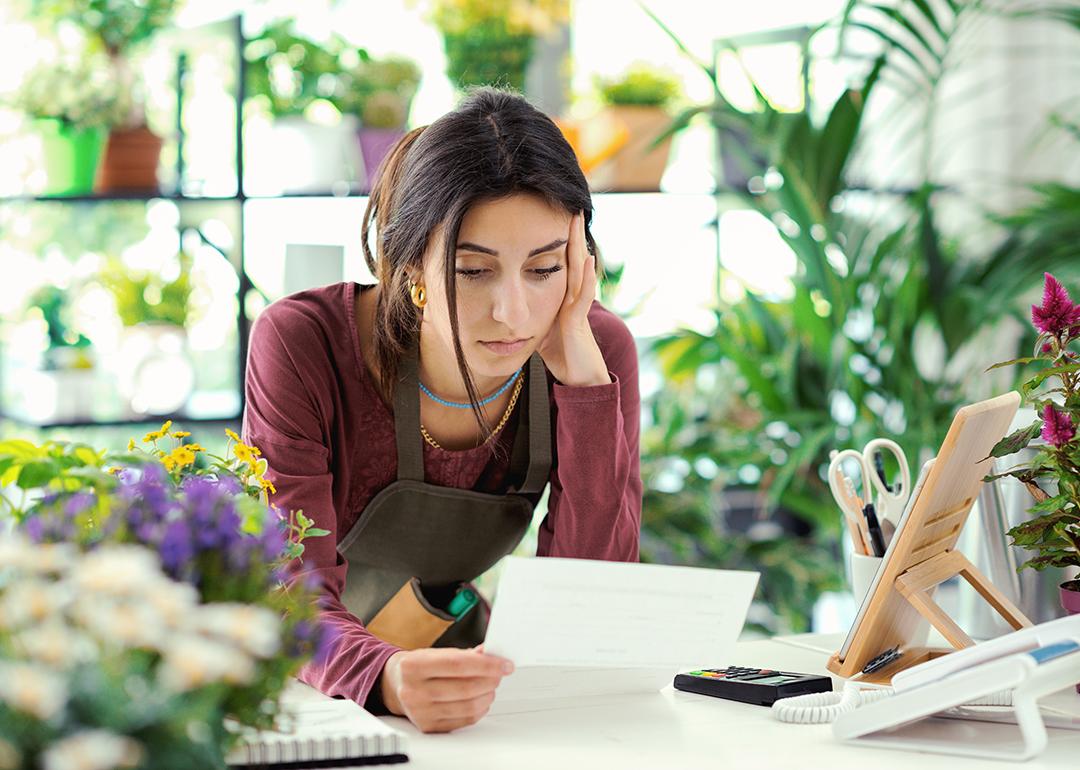 A small plants business owner worried looking at a bill.