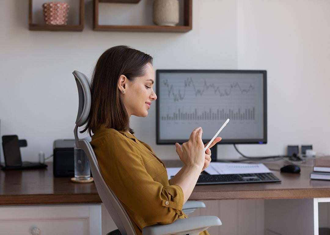 A female finance trader using her smartphone at work.