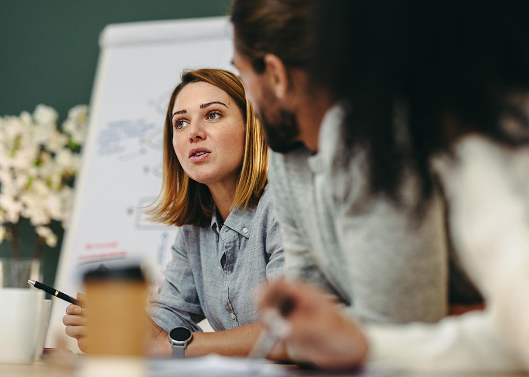 Businesswoman having a discussion with her colleagues in a meeting room.
