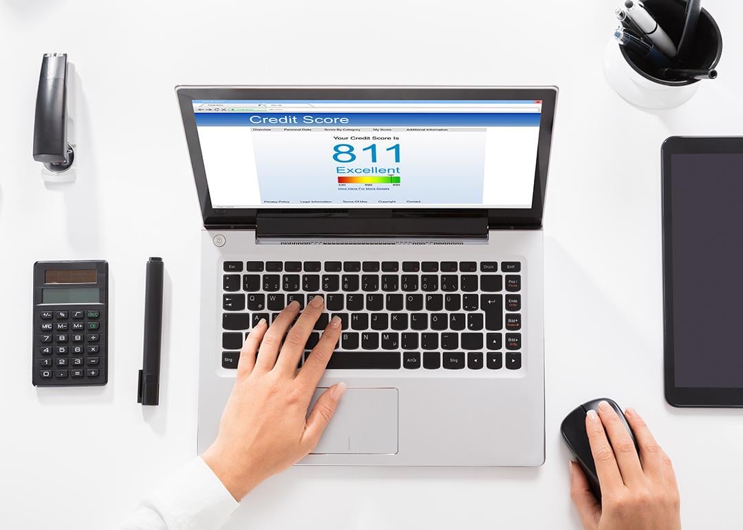 An office table with a laptop showing credit score.