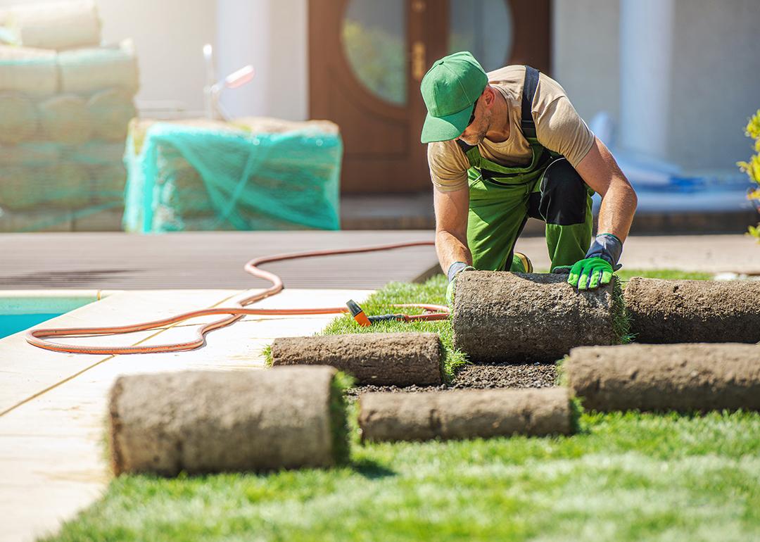 A lawn care professional installing new grass at a home.