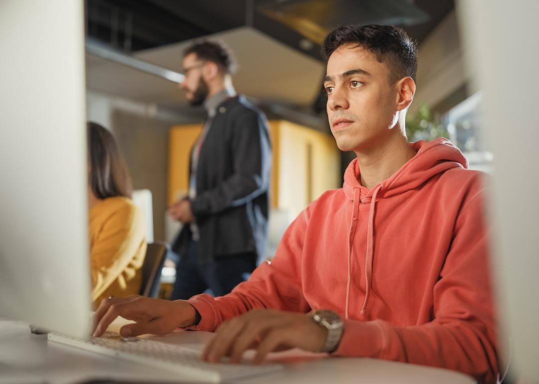 A male student using a desktop computer for application tasks.