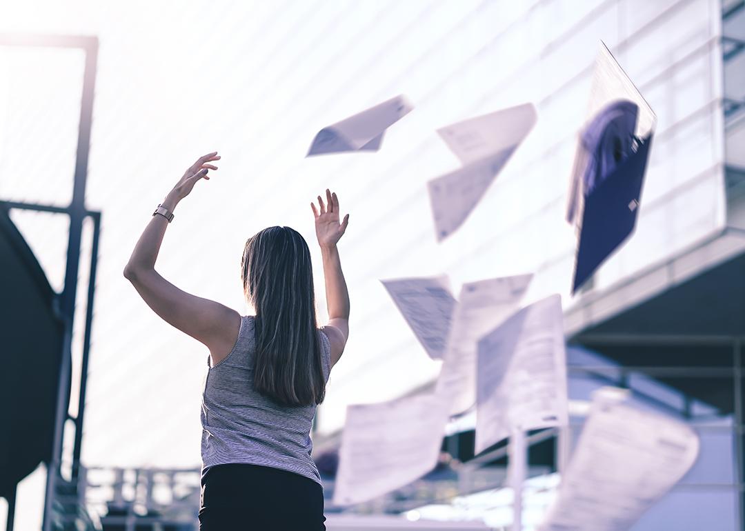 Businesswoman throws paper in the air.
