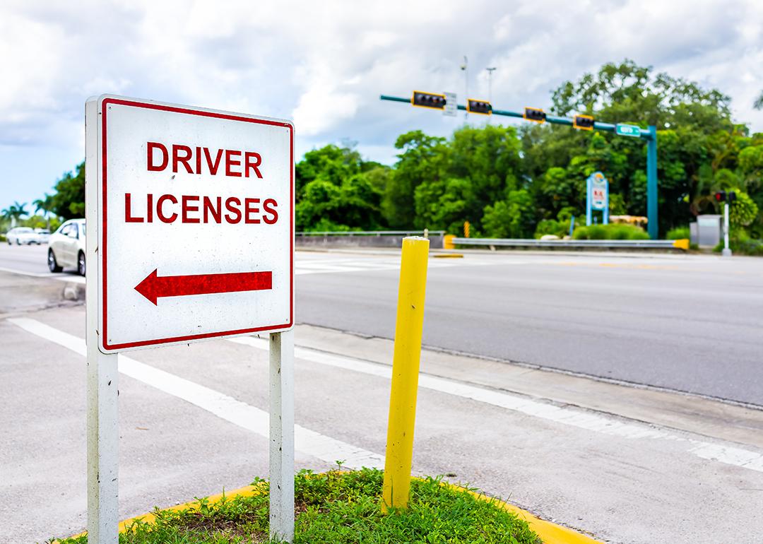 A roadside sign showing direction to a driver's license office.