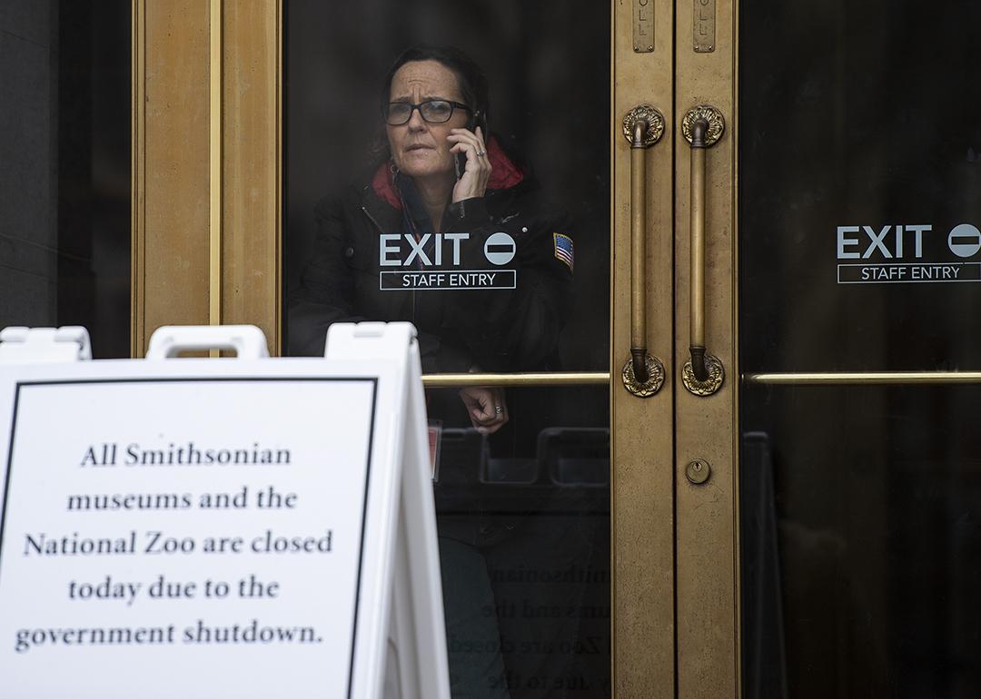 A US government employee talks on the phone as she looks out of a closed Smithsonian museum in Washington, DC on January 18, 2019, where the government has been shut down for four weeks.