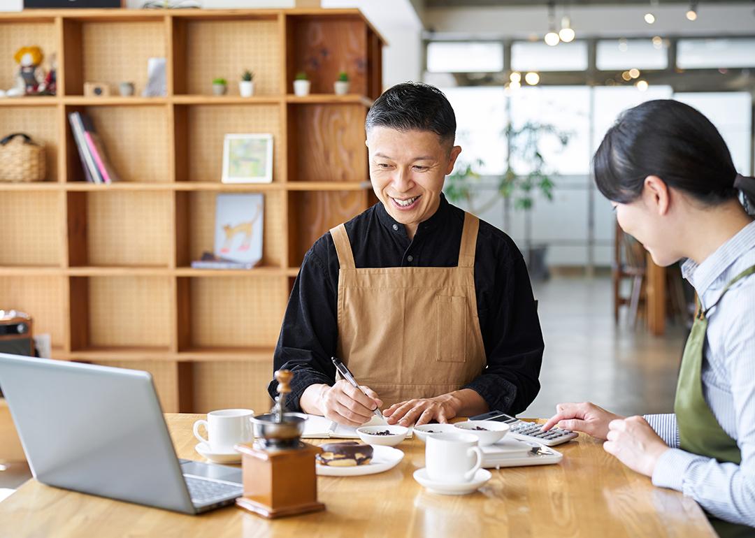 A cafe small business owner calculating costs of products.