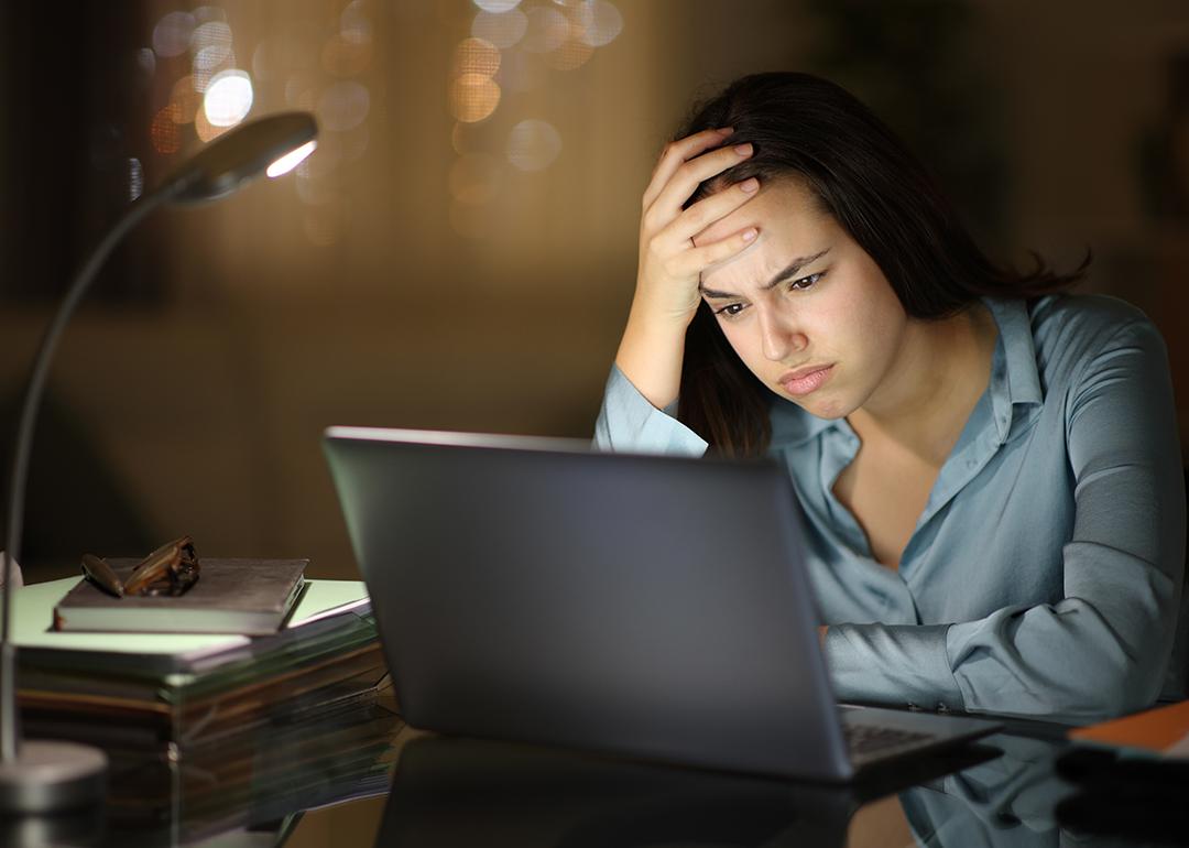 A young female professional frustratingly looks at her laptop at work.