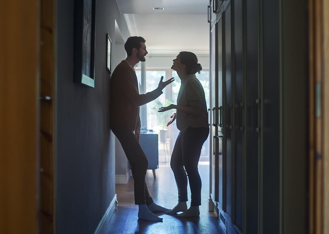 A couple fighting in a hallway of their apartment.