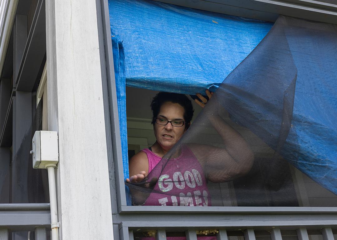 Kristi Naquin shows wind-damaged screens at her 3-year-old home which she says are substandard. They were built as part of the first federally funded relocation project in the United States.