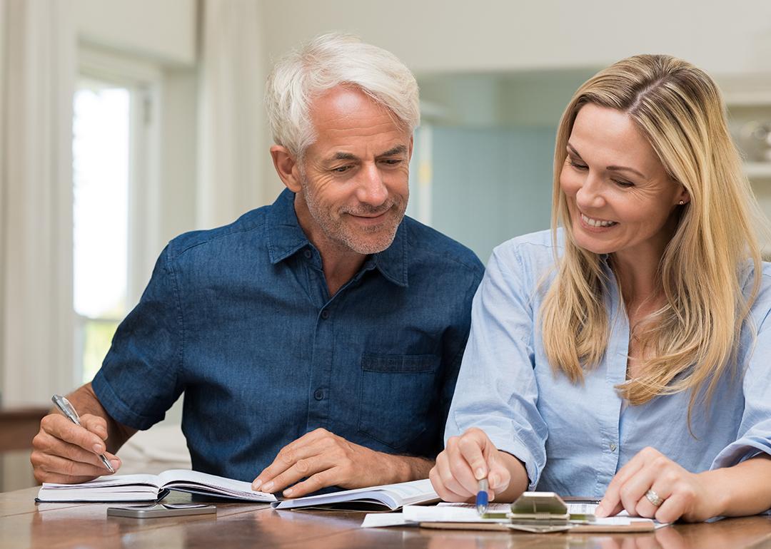 A middle-aged couple reviewing documents at home.